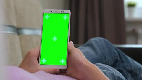 Man lying at sofa and holding phone with green template. Male lying at couch and Video stock 318953320