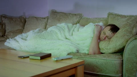 A man lying on the sofa in the evening, watching TV, a boring evening at home Stock Footage 304671503
