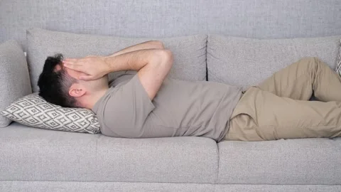 Man lying on sofa headache Stock Footage 265660064