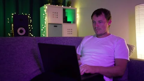 Man lying on sofa with laptop Stock Footage 129117671