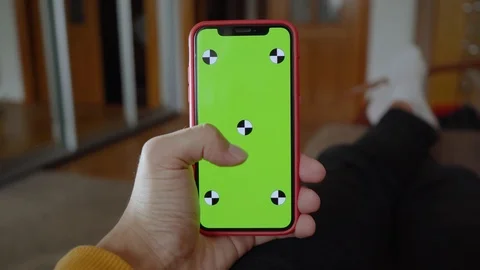 Man lying on sofa use vertical green screen phone at home living room device Stock Footage 118472712