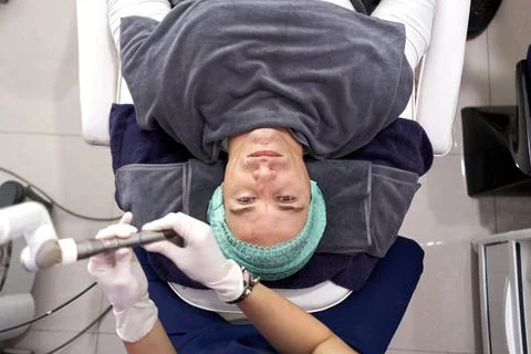 Man lying on a stretcher prepared to receive laser rejuvenation treatment. Stock Photos