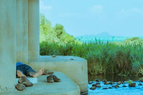 Man lying under bridge Stock Photos