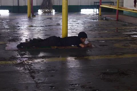A man lying on the vehicle deck aboard a ferry crossing the Sunda Strait Stock-Fotos