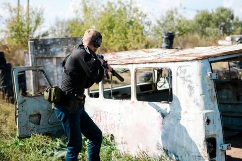 A man with a machine gun learns to shoot at a shooting range Stock Photos
