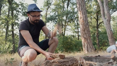 The man made a fire and chopped wood for a picnic in the forest. Stock Footage 114870711