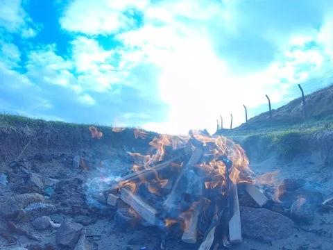 Man-made fire using wooden sticks on Spiddal beach, Galway Ireland Stock Footage 232044426