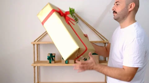 The man made a pine tree decoration from the shelf, he sets the surprise gift bo Vídeo Stock 142076483
