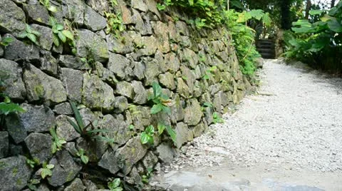 Man made rock wall pathway lead to forest Stock Footage 21136137