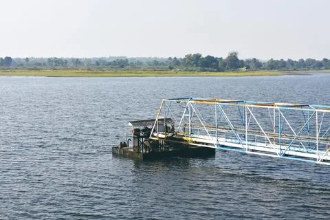 A man made structure between a lake created to intake water with a pump Stock Photos