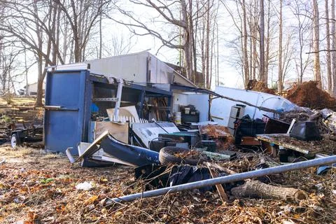 Man made structures in disarray next to trees debris in rural area Stock Photos