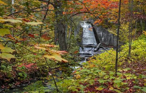 Man made water falls surrounded with fall foliage in Michigan upper peninsula Stock Photos