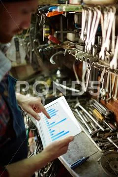 Man in mainenance shop working with data on touchpad Stock Photos