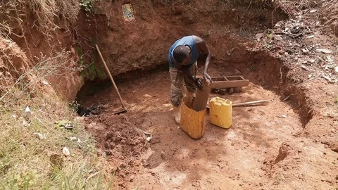 Man make Bricks from adobe pressing wet mud mixture into timber frame Stock Footage 109140189