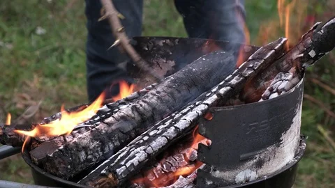 Man make a fire flames from firewoods for preparing grill Video stock 124326870