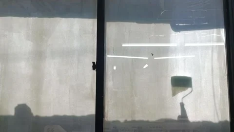 A man make a glass window opaque by using paint for blocking sunlight or for pri Stock Footage 327877014
