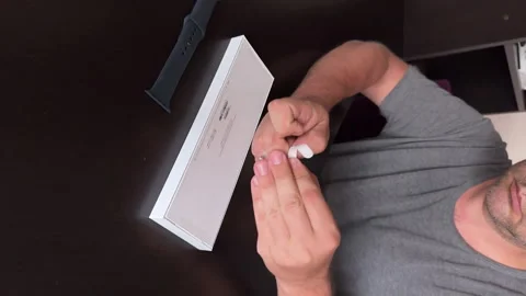 The man makes the Apple Watch Series 9 smart watches. He opens a box with smart  Stock Footage 279740937