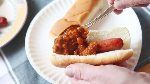 Man makes a chili dog Stock Footage 76743765