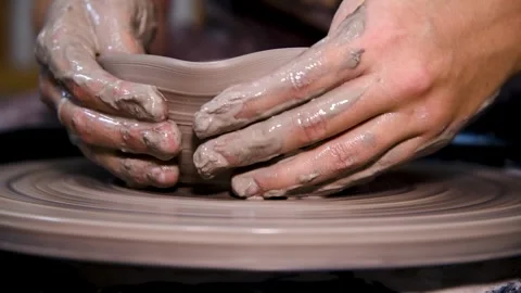 Man makes a clay pot or vase on a potter's wheel Stock Footage 324856160