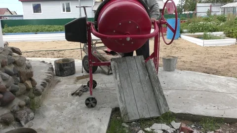 A man makes concrete mortar with a concrete mixer Vídeo Stock 136614943