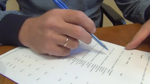 A man makes corrections in entries on a sheet of white paper with a ballpoint pe Stock-Footage 118389108