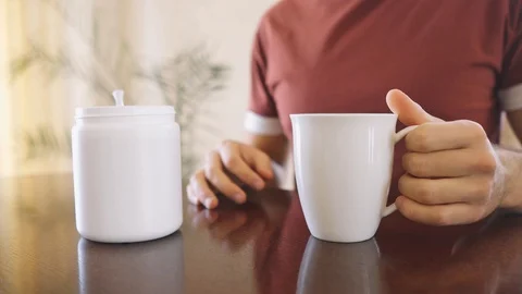 Man makes diet protein shake mixed with water in a glass at the table Stock Footage 126570670