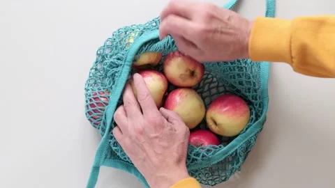 A man makes eco shopping with a reusable sack with apples on the table Video stock 220952691