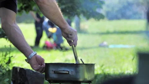 A man makes a fire in a barbecue outside in a park Video stock 242032240