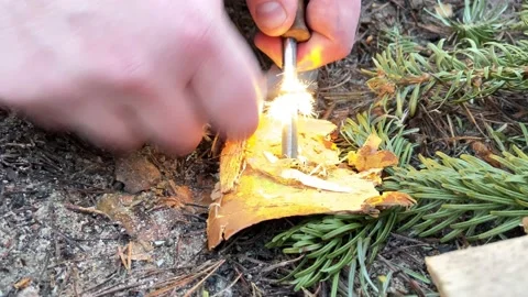 A man makes a fire with a fire steel 스톡 동영상 147147978