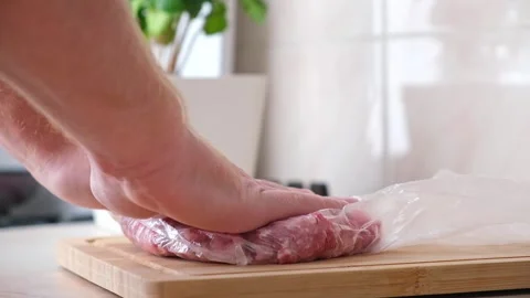 A man makes flat minced pork and beef in bags for storage in freezer. Stock Footage 202089317