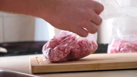 A man makes flat minced pork and beef in bags for storage in freezer. Stock Footage 202287748