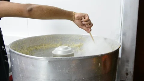 Man makes fluffy cotton candy with special machine at street  Видео 93683307