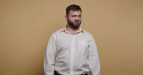 Man makes funny face in plain studio with yellow background during a lighth.. Vídeo Stock 326797488