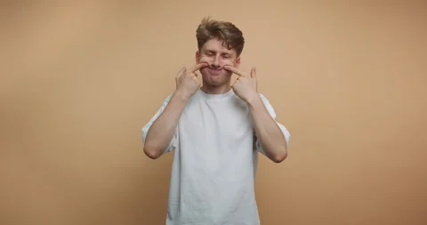 Man makes funny faces in front of plain background in a short series of cli.. Vídeo Stock 328247089