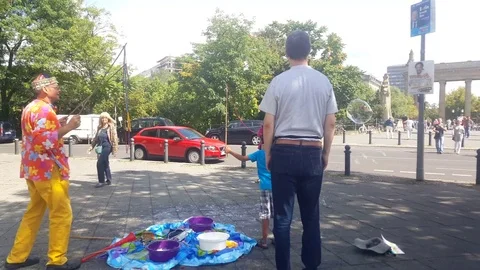 Man makes giant bubbles with father and child, Charlottenburg Gate, Berlin Vídeos de archivo 74655210