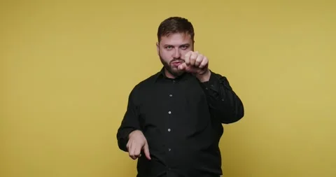 Man makes hand gestures in front of a yellow background at a photography st.. Stock-Footage 326789749