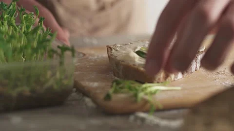 The man makes a healthy sandwich. A slice of rye bread with cream cheese on Stock Footage 154424835