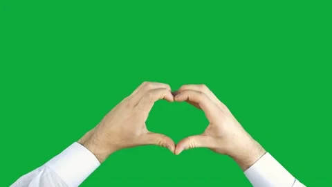 Man makes a heart out of his hands on a green screen Stock Footage 142995406
