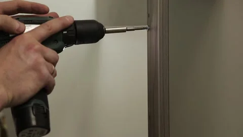 A man makes a hole with an electric screwdriver Video stock 221202253