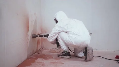 A man makes a hole in the wall for the socket at home. High quality 4k footage Stockbeeldmateriaal 153996763