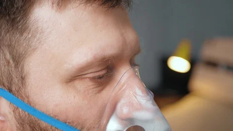 Man makes inhalation using nebulizer. Side view. Slow motion and close-up Stockbeeldmateriaal 123276191