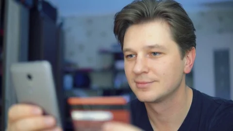 A man makes an internet purchase using a mobile phone. Stock Footage 84568031