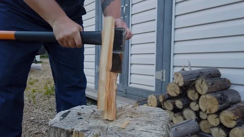 Man makes kindling for fire by splitting a log with ax Video stock 109252742