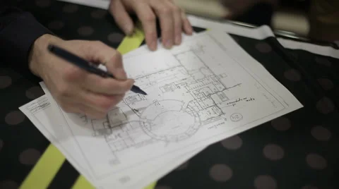 A man makes a mark on the drawing of the building Stock Footage 43157819