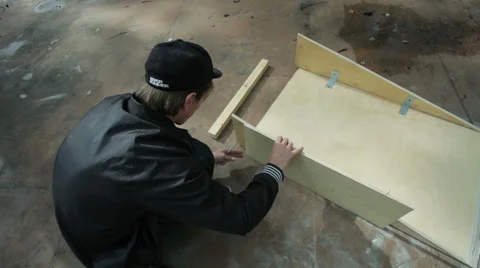 Man makes marks on items made of wood in the skatepark Stock Footage 59242463