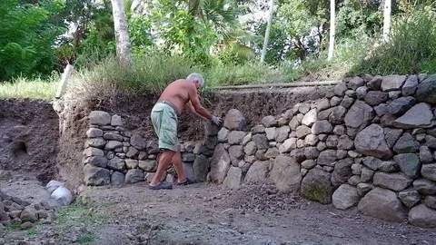 A man makes masonry. Somewhere in a tropical village. Video stock 122909761