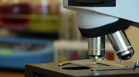 A man makes a microscopy of red drop on slide Stock Footage 63045604