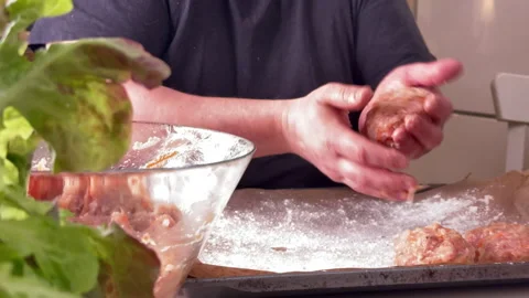 A man makes minced meatballs and puts them on a baking tray Vidéo 304804868