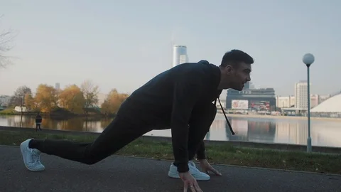 A man makes a morning stretch against the backdrop of the cityscape Stockbeeldmateriaal 121482014