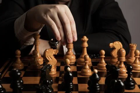Man makes a move chess figure Stock Photos